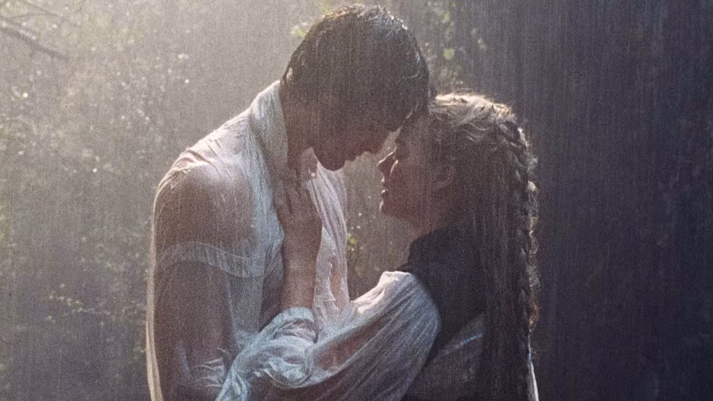 Catherine Earnshaw and Heathcliff stand close together in heavy rain, gazing at each other during an intense scene in Wuthering Heights (2026).