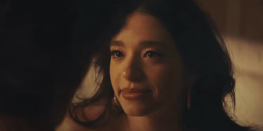 Mikey Madison as Ani looks softly at someone off camera in a warm, close-up scene from Anora.