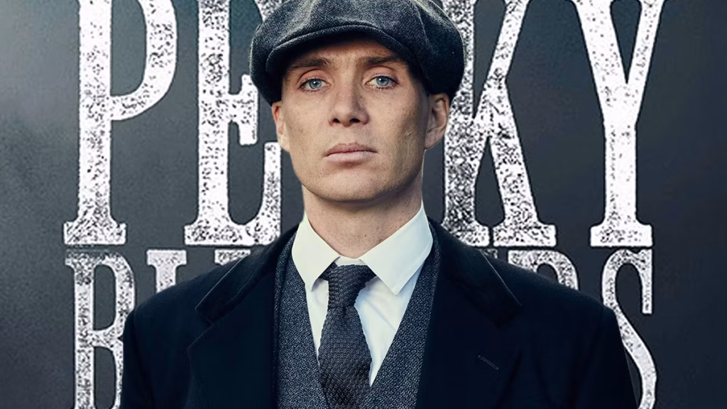 Cillian Murphy as Tommy Shelby stands in period clothing with a serious expression in a dark, moody promotional image from Peaky Blinders: The Immortal Man.