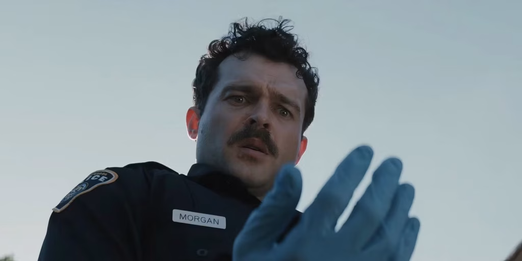 Officer Morgan looks at his blue glove after being pricked during an investigation in Weapons.