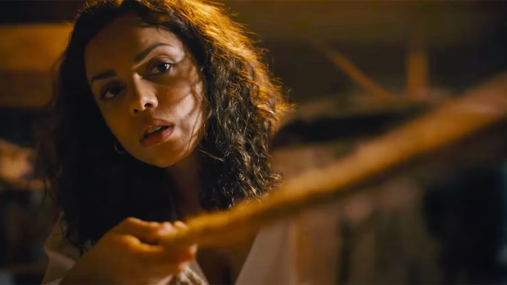 Georgina Campbell examines something in a dark scene from Barbarian.
