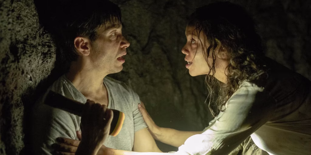 Justin Long as AJ and Georgina Campbell as Tess face each other in a dark tunnel in Barbarian.