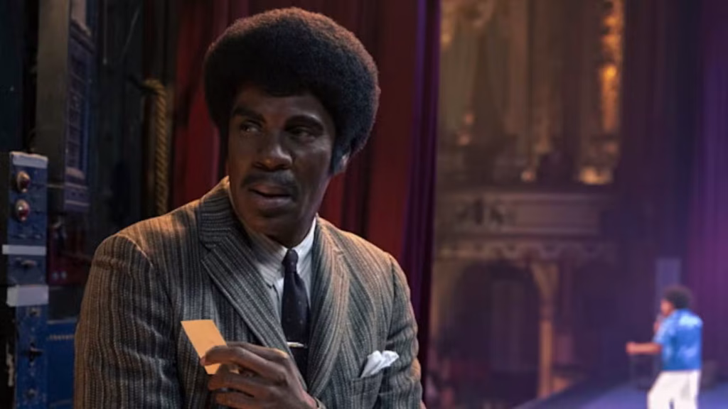 Colman Domingo as Joe Jackson stands backstage while young Michael Jackson performs.