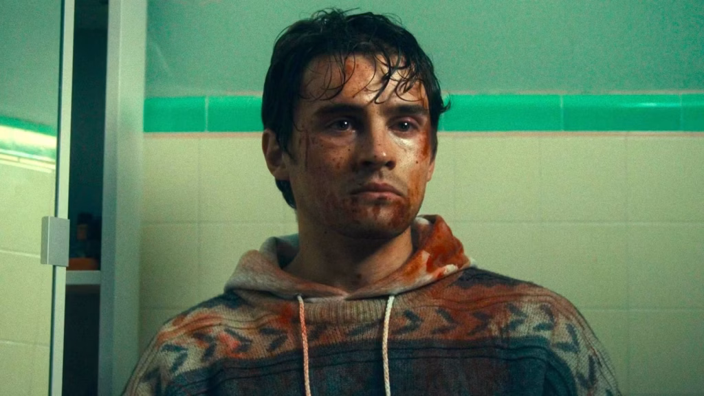 A bloodied Bear stands in a tiled bathroom during a tense scene in Obsession.