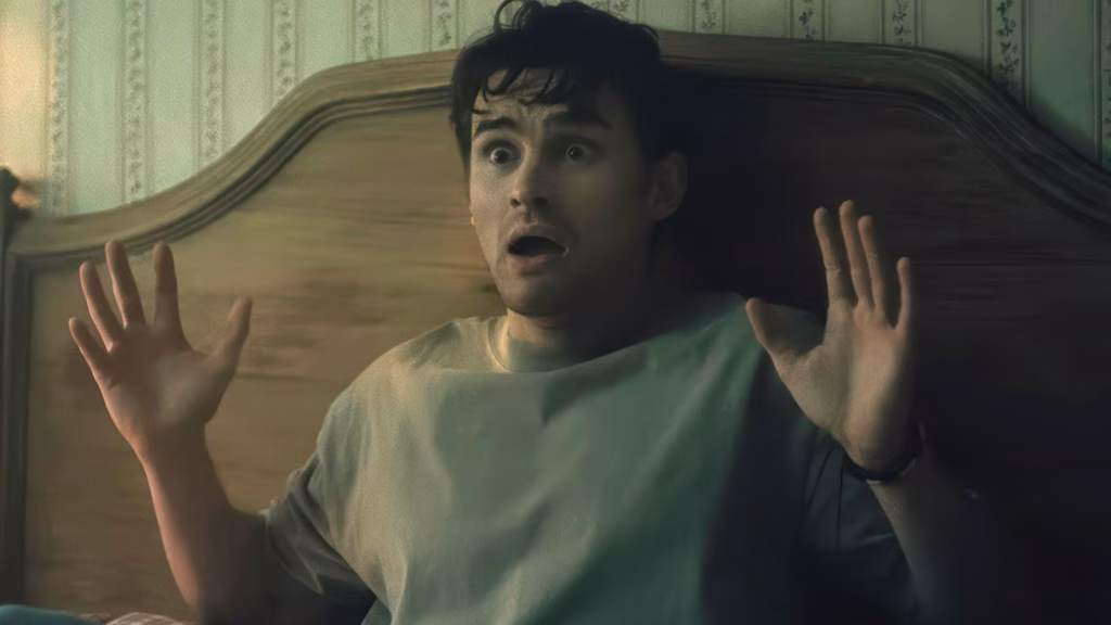 A frightened Bear raises both hands while sitting upright in bed in Obsession.