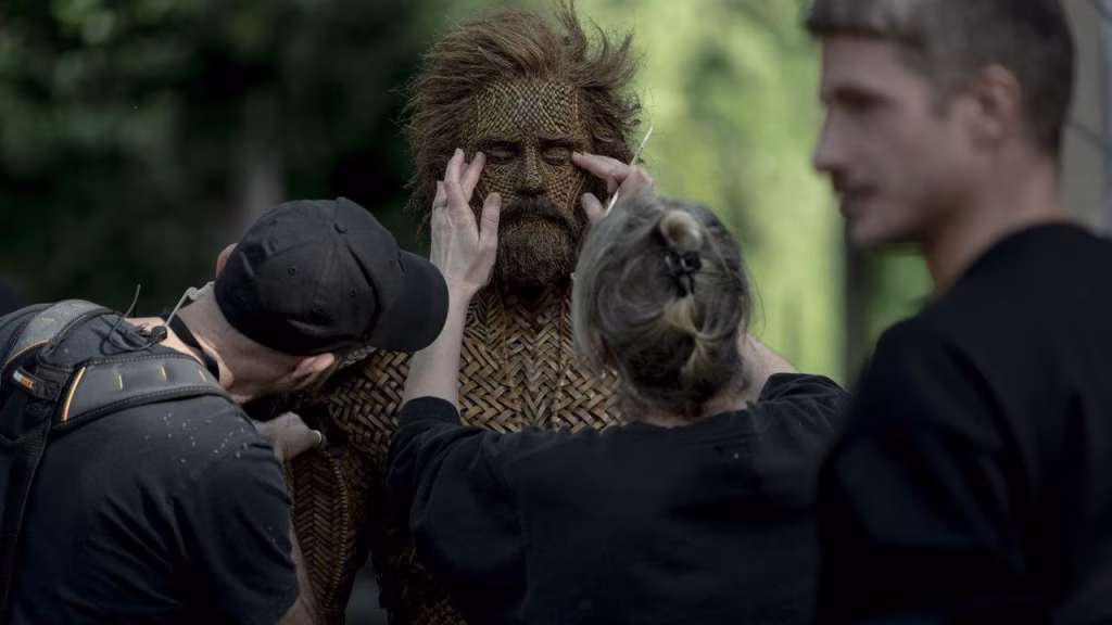 Crew members adjust Alexander Skarsgård’s woven face and body prosthetics on the set of Wicker.